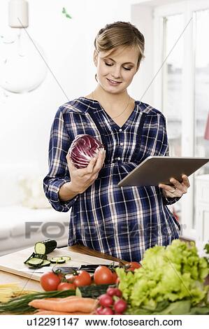 Woman using tablet computer to cook View Large Photo Image Stock Photo - Woman using tablet computer to cook. Fotosearch