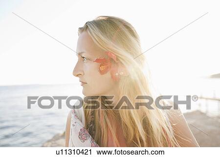 Stock Image - Woman wearing flower in her hair. Fotosearch