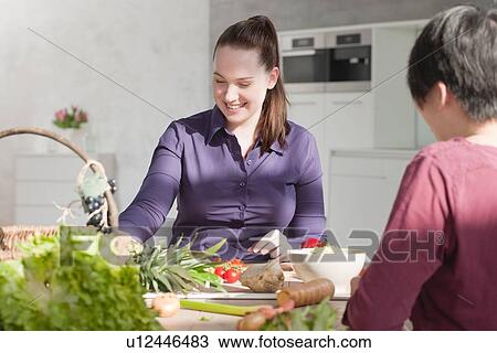 Women eating vegetables in kitchen View Large Photo Image Stock Image - Women eating vegetables in kitchen. Fotosearch