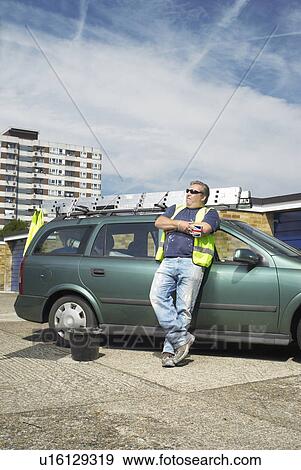 Worker leaning against car on site View Large Photo Image Stock Photo - Worker leaning against car on site. Fotosearch