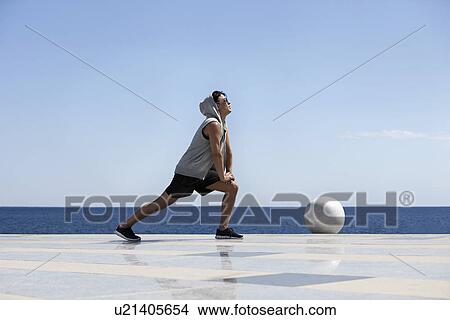 Young man stretching near ocean View Large Photo Image Picture - Young man stretching near ocean. Fotosearch