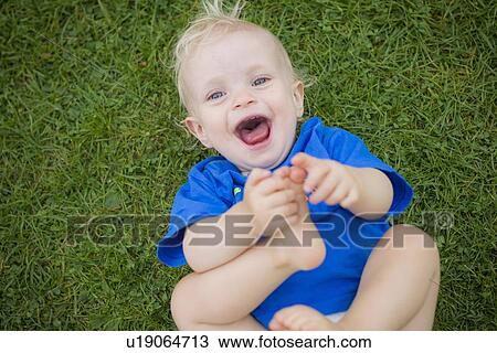 Stock Image - Baby boy playing with his feet. Fotosearch