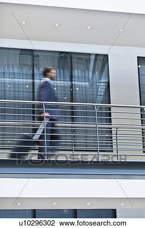 Stock Image - Blurred view of businessman on balcony. Fotosearch