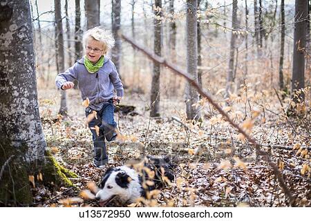 Boy and dog exploring in forest View Large Photo Image Stock Image - Boy and dog exploring in forest. Fotosearch