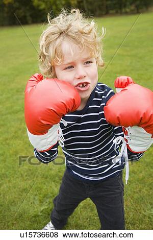 Boy playing with boxing gloves outdoors View Large Photo Image Stock Photo - Boy playing with boxing gloves outdoors. Fotosearch