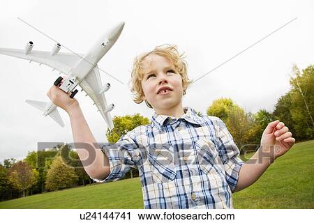 Boy playing with toy airplane outdoors View Large Photo Image Stock Image - Boy playing with toy airplane outdoors. Fotosearch