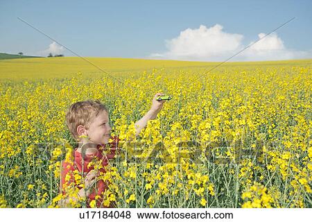 Boy playing with toy car in field View Large Photo Image Stock Photo - Boy playing with toy car in field. Fotosearch
