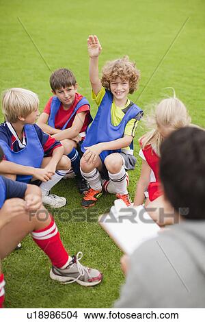 Picture - Boy raising his hand during practice. Fotosearch