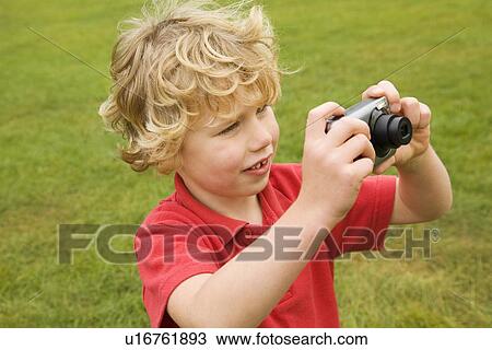 Boy taking pictures outdoors View Large Photo Image Stock Image - Boy taking pictures outdoors. Fotosearch