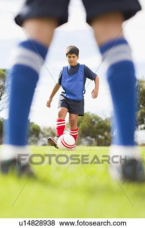 Boys playing soccer on pitch View Large Photo Image Stock Photo - Boys playing soccer on pitch. Fotosearch