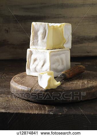 Stock Image - Brie cheese on wooden board. Fotosearch