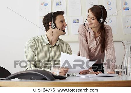 Stock Photograph - Business people in headsets in office. Fotosearch