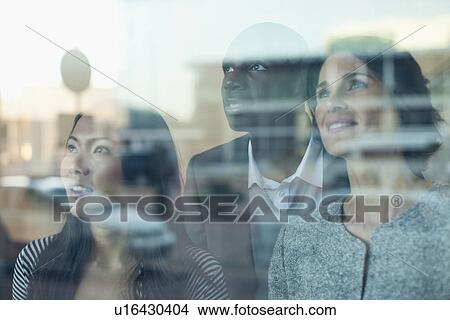 Picture - Business people looking out window. Fotosearch