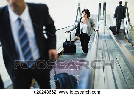 Business people riding escalator View Large Photo Image Stock Image - Business people riding escalator. Fotosearch
