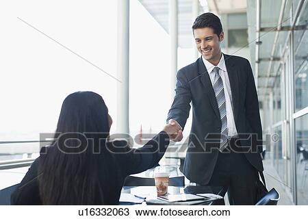 Business people shaking hands in cafe View Large Photo Image Stock Image - Business people shaking hands in cafe. Fotosearch