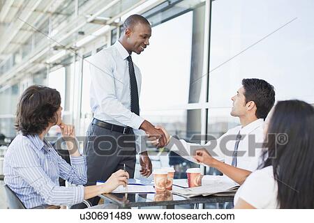 Business people shaking hands in cafe View Large Photo Image Stock Photo - Business people shaking hands in cafe. Fotosearch