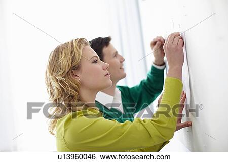 Stock Photograph - Business people tacking up signs. Fotosearch
