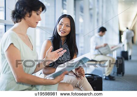 Stock Image - Business people talking in hallway. Fotosearch