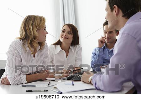 Stock Image - Business people talking in meeting. Fotosearch