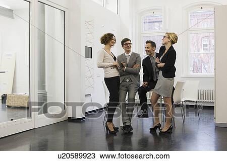 Stock Image - Business people talking in office. Fotosearch