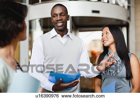 Stock Photograph - Business people talking outside building. Fotosearch