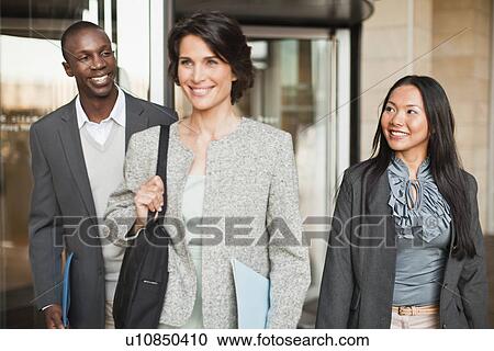Stock Image - Business people walking outside building. Fotosearch