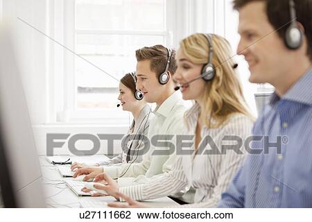 Stock Image - Business people working in headsets. Fotosearch