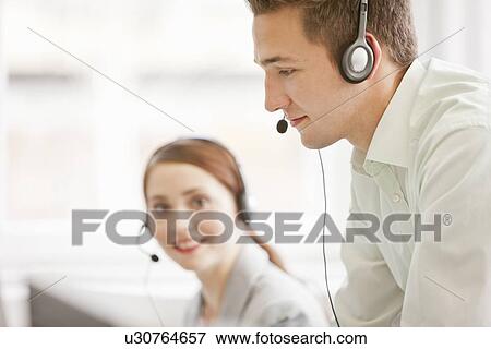 Stock Photo - Business people working in headsets. Fotosearch