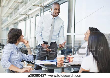Stock Photo - Business people working together in cafe. Fotosearch