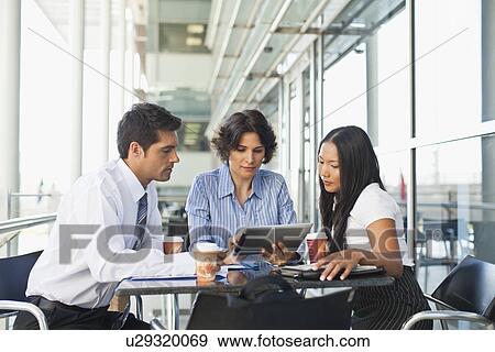 Business people working together in cafe View Large Photo Image Stock Photo - Business people working together in cafe. Fotosearch
