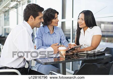Business people working together in cafe View Large Photo Image Stock Photograph - Business people working together in cafe. Fotosearch