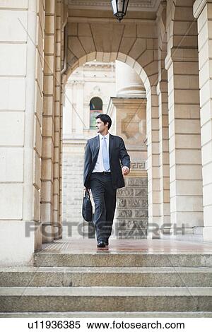 Stock Photography - Businessman climbing steps of building. Fotosearch