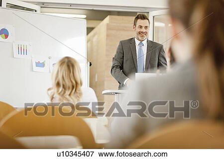 Businessman hosting seminar in office View Large Photo Image Stock Photo - Businessman hosting seminar in office. Fotosearch