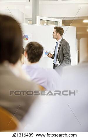 Stock Photo - Businessman hosting seminar in office. Fotosearch
