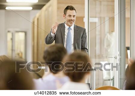 Stock Photography - Businessman hosting seminar in office. Fotosearch