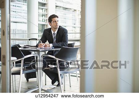 Businessman making notes in cafe View Large Photo Image Stock Photo - Businessman making notes in cafe. Fotosearch