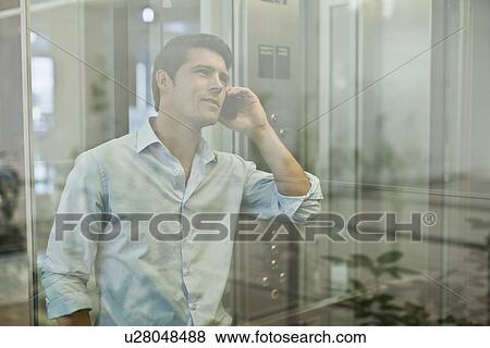 Businessman on cell phone in elevator View Large Photo Image Stock Photo - Businessman on cell phone in elevator. Fotosearch
