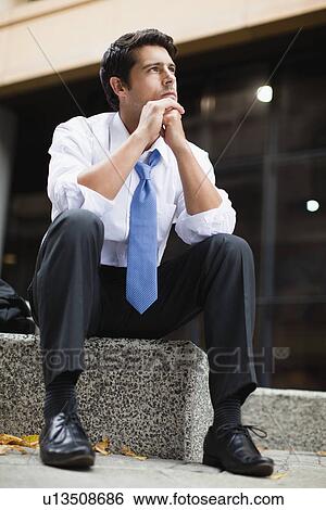 Businessman sitting on city street View Large Photo Image Stock Photograph - Businessman sitting on city street. Fotosearch