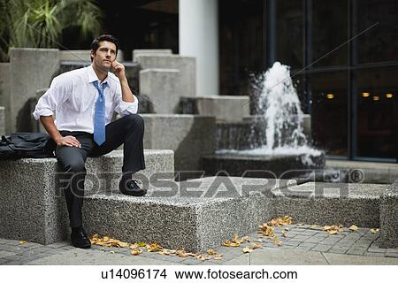 Businessman sitting on urban fountain View Large Photo Image Picture - Businessman sitting on urban fountain. Fotosearch