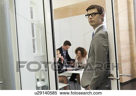 Businessman standing in doorway View Large Photo Image Stock Photography - Businessman standing in doorway. Fotosearch