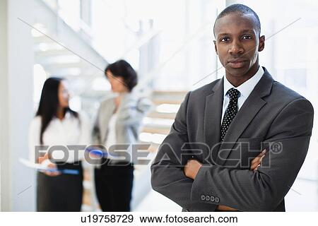 Businessman standing in office View Large Photo Image Stock Photo - Businessman standing in office. Fotosearch
