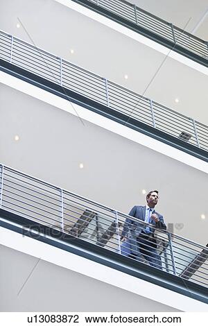 Stock Image - Businessman standing on balcony. Fotosearch