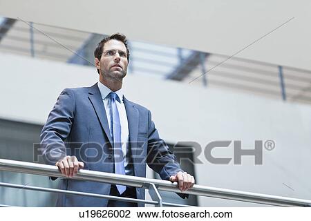 Businessman standing on balcony View Large Photo Image Stock Image - Businessman standing on balcony. Fotosearch