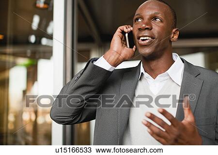 Stock Image - Businessman talking on cell phone. Fotosearch