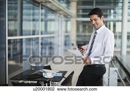 Businessman using cell phone in cafe View Large Photo Image Stock Image - Businessman using cell phone in cafe. Fotosearch