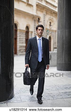 Picture - Businessman walking on city street. Fotosearch