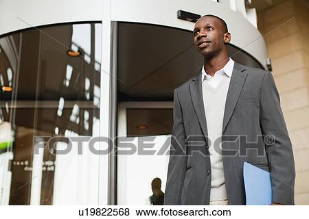 Stock Photo - Businessman walking outside building. Fotosearch