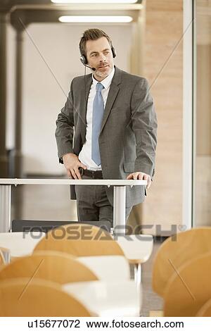 Businessman wearing headset at podium View Large Photo Image Stock Image - Businessman wearing headset at podium. Fotosearch