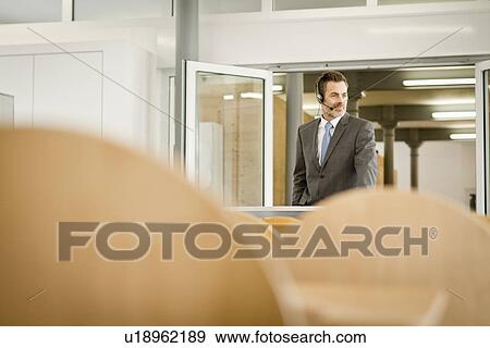 Businessman wearing headset at podium View Large Photo Image Stock Photo - Businessman wearing headset at podium. Fotosearch