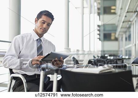 Stock Image - Businessman with tablet computer in cafe. Fotosearch